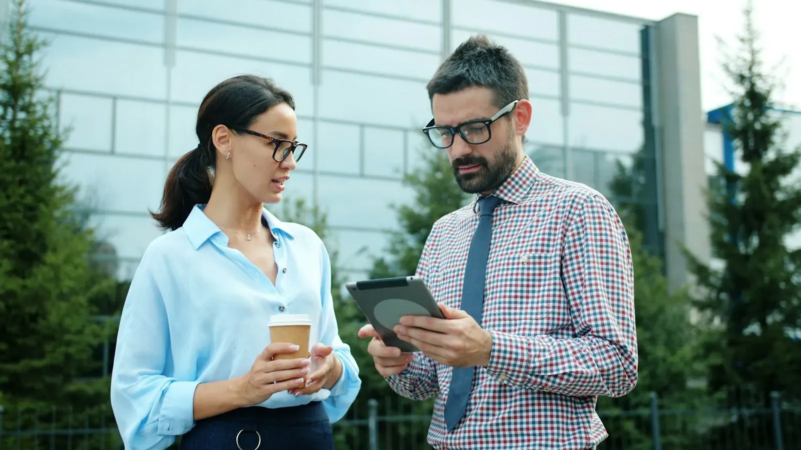 Dos asesores conversando sobre un reporte en una tablet